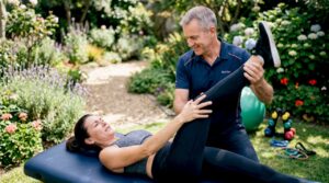 Physical therapist assisting patient recovery exercise